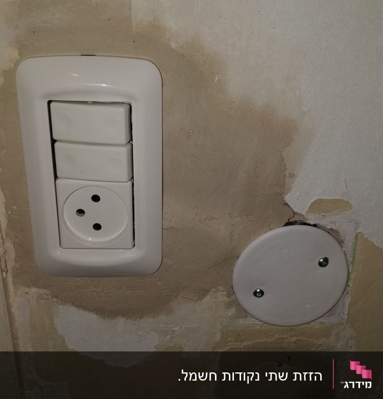 שקע חשמל ומתגים על קיר עם טיח מתקלף